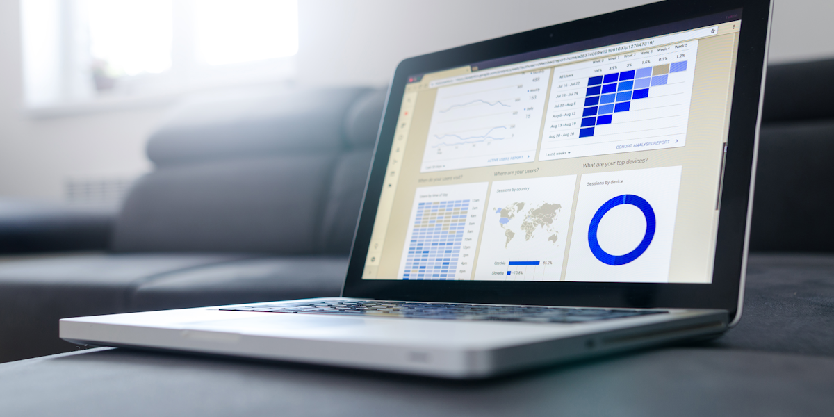 Person working at a desk with multiple monitors showing data